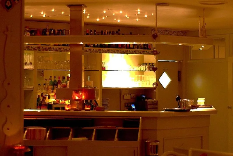 Barbereich mit beleuchteter Theke und Flaschenregal